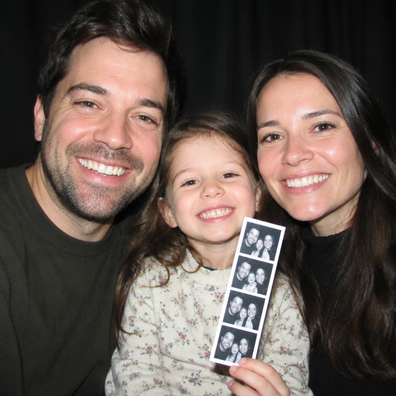 Family holding a printed photo strip