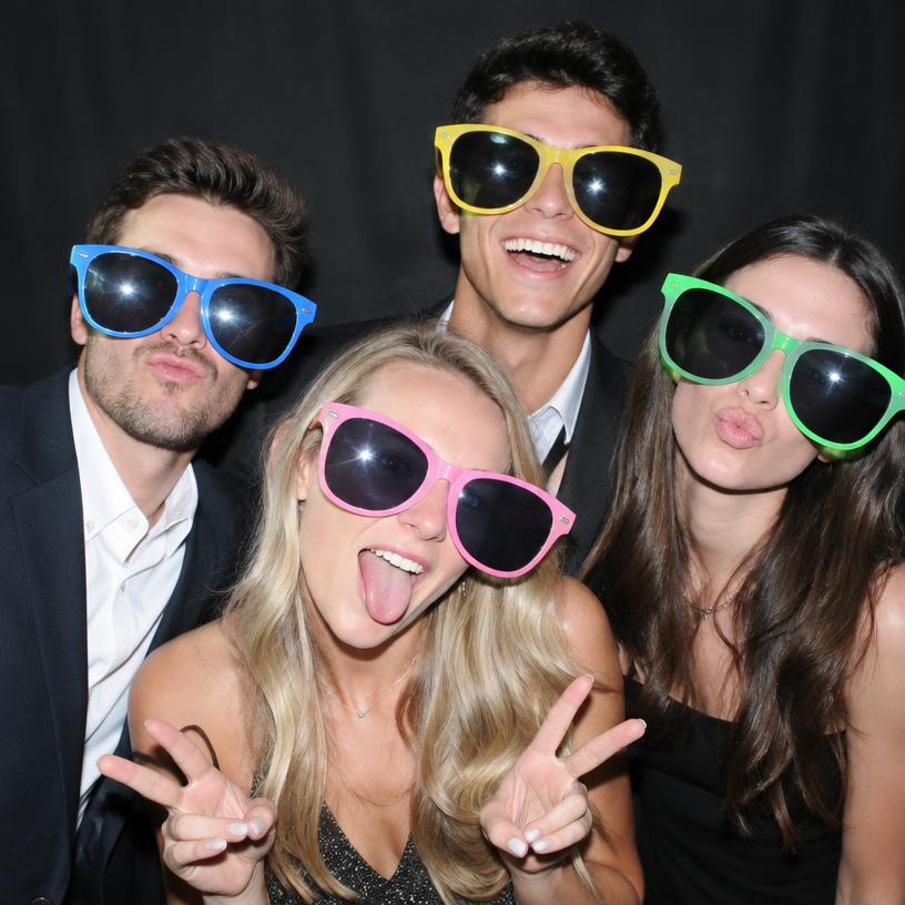 Friends posing with oversized sunglasses