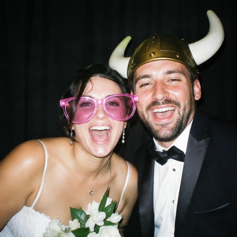 Couple laughing with props at a wedding